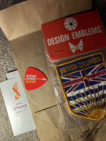 Business card, free pick from Guitar Lovers 2023 event, British Columbia patch in the wild